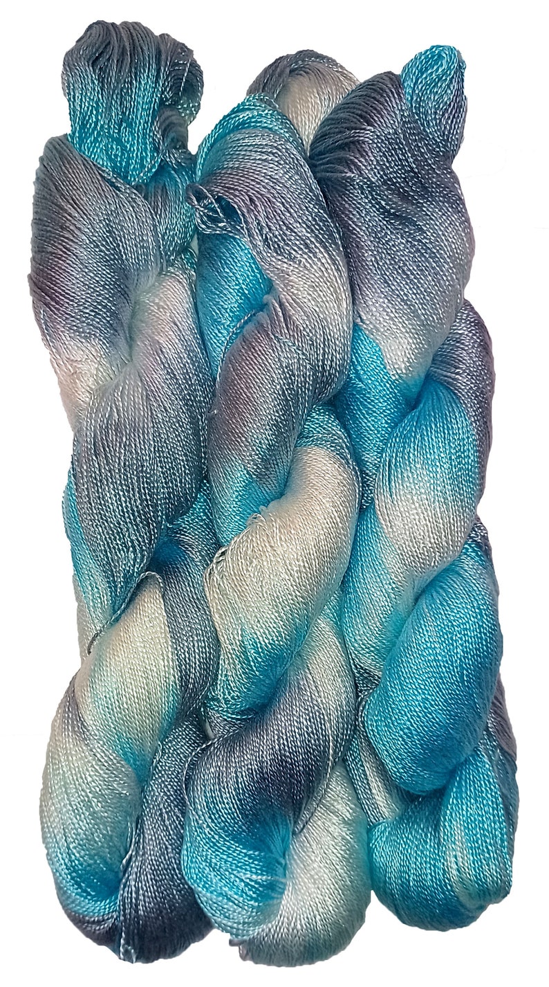 May include: A skein of blue, white, and gray yarn with a gradient color pattern. The yarn is made of silk and is soft and smooth.