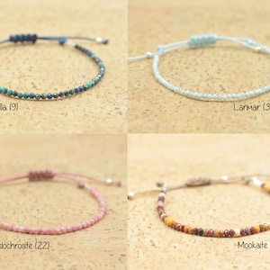 May include: Four different gemstone bracelets with adjustable string closures. The bracelets are made with small, round beads in the following colors: turquoise, light blue, pink, and brown with red and yellow accents. The bracelets are labeled with the gemstone names and bead counts: Chrysocolla (9), Larimar (31), Rhodochrosite (22), and Mookaite (26).