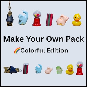 Könnte beinhalten: Eine Sammlung farbenfroher Miniaturfiguren, darunter eine Fledermaus, ein Elefant, ein Kaugummiautomat und eine Ente. Der Text "Make Your Own Pack - Colorful Edition" ist unter den Figuren zu sehen.