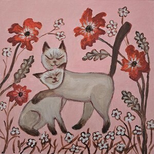 May include: Two Siamese cats cuddling in a field of pink flowers. The cats are white with brown markings and have closed eyes. The flowers are red and white.