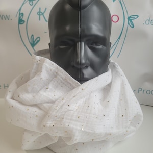 Könnte beinhalten: Weißer, leichter Schal mit goldenen Metallic-Flecken. Der Schal ist um einen Schaufensterpuppenkopf drapiert. Der Stoff scheint ein weiches, strukturiertes Material zu sein. Neutrales Accessoire.