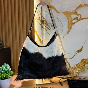 May include: A set of three ceramic mugs with a speckled, matte finish. The mugs are in shades of cream, light gray, and dark gray. Each mug has a simple, minimalist design, perfect for coffee or tea.