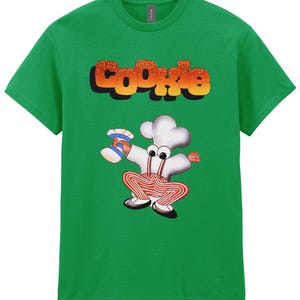 May include: Green t-shirt with a cartoon chef character holding a cookie and the word "COOKIE" in a retro font.