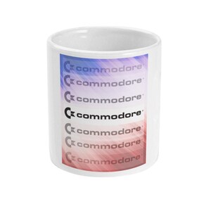 Peut inclure: Une tasse en céramique blanche avec un fond dégradé coloré et le mot "commodore" répété plusieurs fois en texte noir.