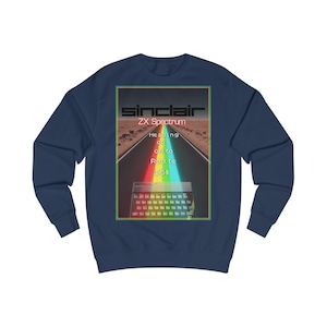 May include: Navy blue sweatshirt featuring a retro graphic. The graphic includes the text "Sinclair ZX Spectrum" above a road scene with a rainbow and a keyboard. The text "Heading out to Route 16k" is also present.