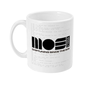 Op de afbeelding: Witte keramische mok met een zwart-witte afbeelding. De afbeelding bevat de tekst "MOE", "6581 SID" en "CHIPTUNING SINCE THE 80S", samen met regels code. De mok heeft een gebogen handvat.