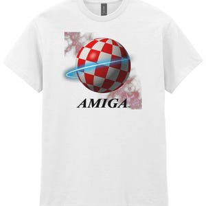 May include: White t-shirt featuring a red and white chequered sphere with a blue ring around it. The text "AMIGA" is below the sphere.