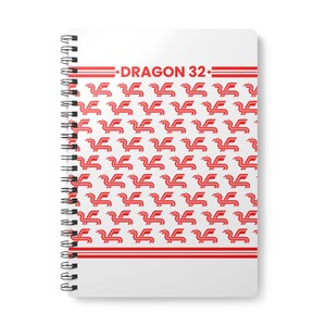Könnte beinhalten: Ein weißes Spiralnotizbuch mit einem roten Drachenlogo und dem Text "DRAGON 32", der sich über die gesamte Vorderseite wiederholt.