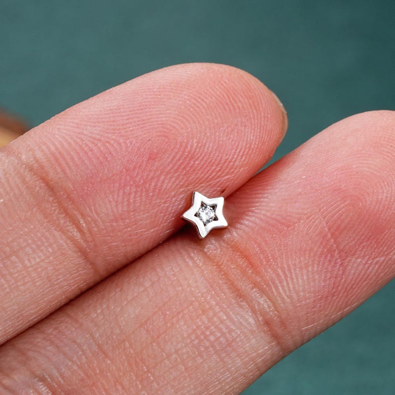 May include: A small silver star-shaped stud earring with a single clear rhinestone in the center.