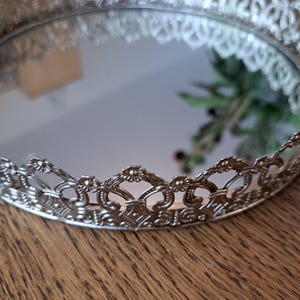 Mirror tray with an openwork silver-colored metal edge.