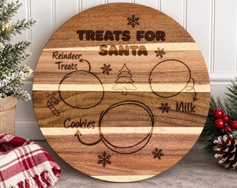 May include: A round wooden serving board featuring laser-engraved text that reads TREATS FOR SANTA, Reindeer Treats, Cookies, and Milk. The board includes circular outlines for food placement, a Christmas tree, snowflakes, and a candy cane.