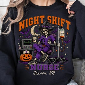May include: A black crewneck sweatshirt featuring a graphic of a skeleton nurse in a purple scrub set and witch hat, holding a coffee cup. The design includes a pumpkin, IV drip, heart monitor, bats, and the text "NIGHT SHIFT NURSE Jessica, RN".