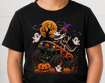 May include: A black t-shirt featuring a graphic of a skeleton dinosaur wearing a purple witch hat and sunglasses, driving an orange monster truck decorated with jack-o'-lanterns. The scene includes a full moon, bats, and ghosts.