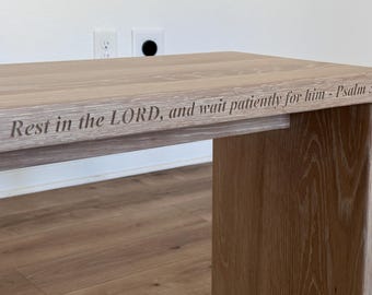 Banco grande de roble blanco con grabado de versículos bíblicos.