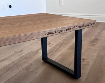 Mesa de centro de roble blanco con patas de metal y versículo bíblico grabado.