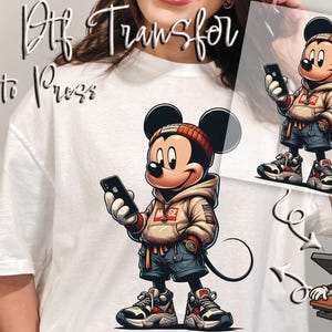 May include: DTF transfer featuring a cartoon Mickey Mouse character in a streetwear style, holding a smartphone. The design includes a red and white beanie, a tan hoodie, blue shorts, and sneakers. The text "Ready to Press" is visible.