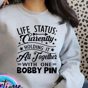 Design de humor relacionável | Status de vida: atualmente mantendo tudo junto com um grampo de cabelo | Arquivo SVG | Corte de silhueta Cricut | Design de camiseta
