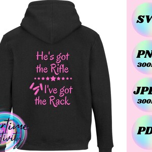 May include: Black hooded sweatshirt with pink text that reads "He's got the Rifle I've got the Rack" with a row of stars and bullet casings.