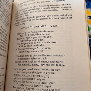 Op de afbeelding: Open boek met tekst "Little Things Mean a Lot" op een cr&egrave;mekleurige pagina. De tekst is in zwarte letters. Het boek is geopend op pagina 279, met het woord "Attentiveness" bovenaan.