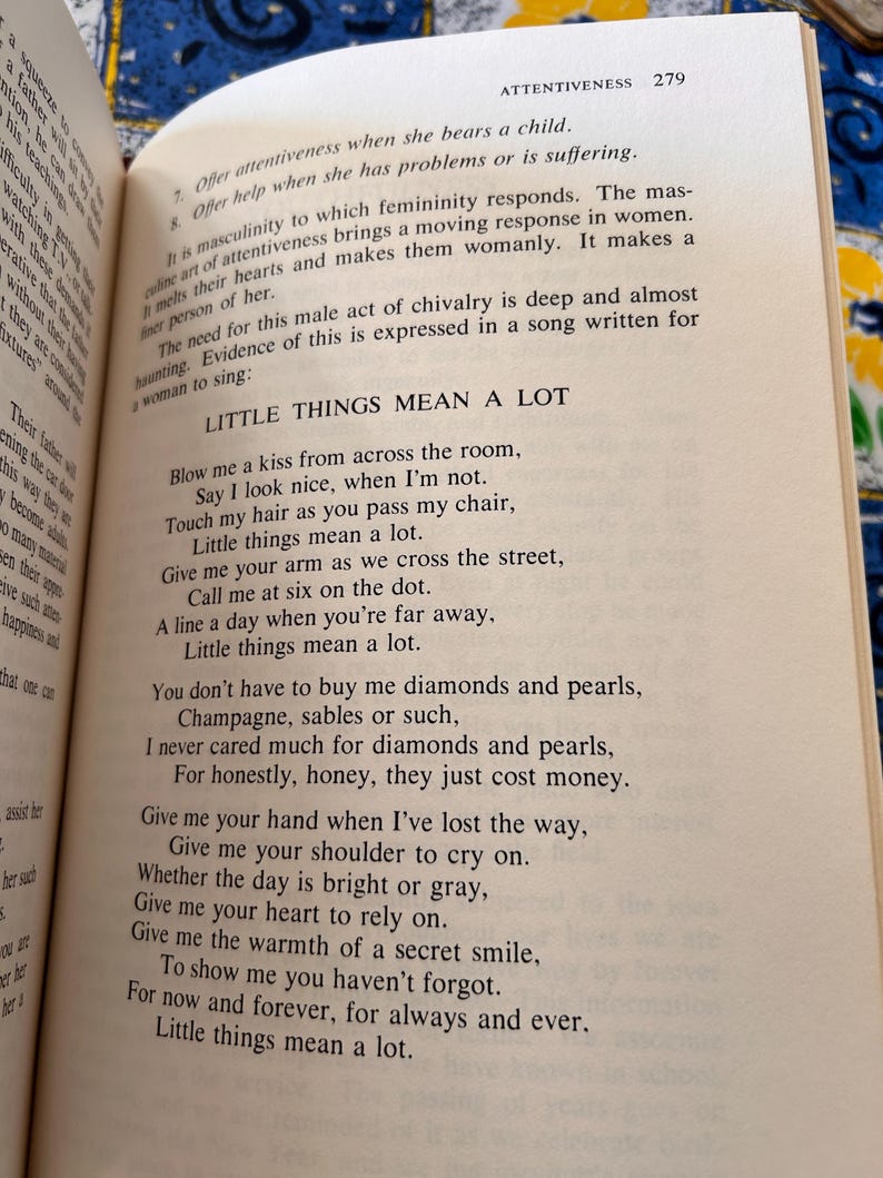 Op de afbeelding: Open boek met tekst "Little Things Mean a Lot" op een cr&egrave;mekleurige pagina. De tekst is in zwarte letters. Het boek is geopend op pagina 279, met het woord "Attentiveness" bovenaan.