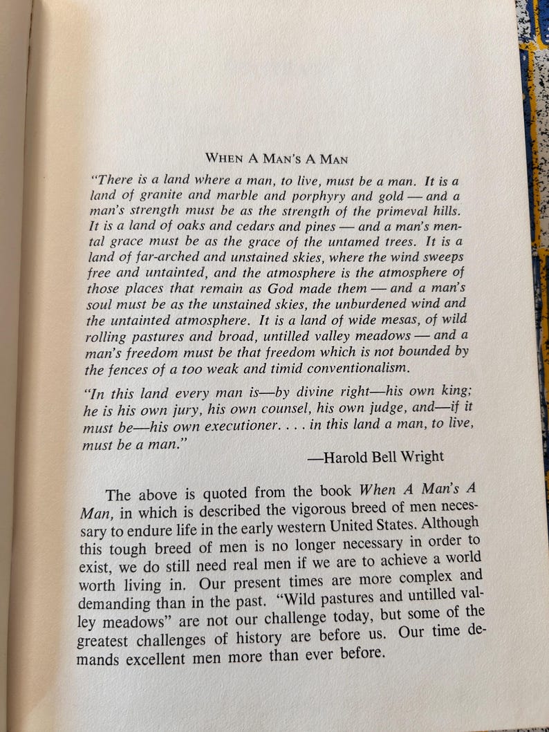 Op de afbeelding: Open boekpagina met de titel "When A Man's A Man" van Harold Bell Wright. De tekst staat in zwarte letters op een cr&egrave;mekleurige pagina. Het boek is open op een pagina met tekst.