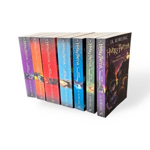 May include: A collection of seven hardcover books from the Harry Potter series by J.K. Rowling. The book spines are visible, each with a unique color scheme and title. The first book is titled "Harry Potter and the Philosopher's Stone".