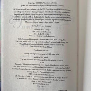 Puede incluir: P&aacute;ginas de libro abierto con texto sobre derechos de autor, informaci&oacute;n de publicaci&oacute;n y un resumen de "The Land of Stories: The Wishing Spell" de Chris Colfer. El libro tiene ISBN 978-0-316-20157-5.