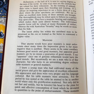 Op de afbeelding: Open boek met gedrukte tekst op een witte pagina. De tekst bevat de titel "MAN OF STEEL AND VELVET" en bespreekt verfijning en manieren. Het boek is open op een pagina met gedrukte tekst.