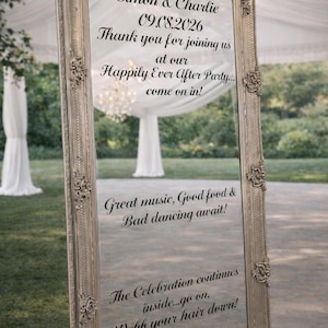 May include: A tall, rectangular floor mirror with an ornate, metallic silver frame. The glass surface features black printed text: Simon & Charlie, 09.08.2026, Thank you for joining us at our Happily Ever After Party... come on in! Great music, Good food & Bad dancing await! The Celebration continues inside...go on, Webb your hair down!