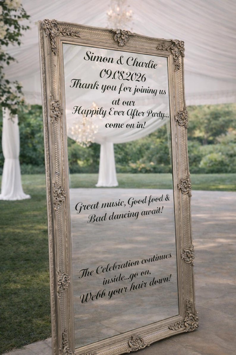 May include: A tall, rectangular floor mirror with an ornate, metallic silver frame. The glass surface features black printed text: Simon & Charlie, 09.08.2026, Thank you for joining us at our Happily Ever After Party... come on in! Great music, Good food & Bad dancing await! The Celebration continues inside...go on, Webb your hair down!