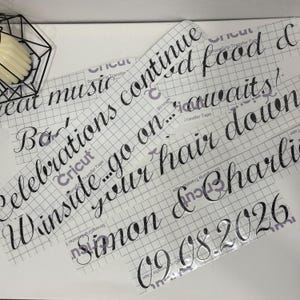 May include: Black vinyl lettering decals on clear transfer tape with a grid pattern. The text reads: Great music, good food & celebrations continue... go on... winside your hair down, Simon & Charlie, 09.08.2026. The decals feature a cursive script font.