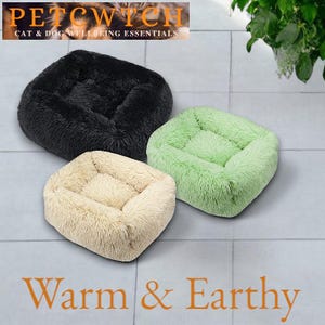 May include: Three plush pet beds in black, light green, and beige. The beds are square with a raised rim and a soft, fluffy texture. The text "PETCWITCH CAT & DOG WELLBEING ESSENTIALS" is at the top. The words "Warm & Earthy" are at the bottom.