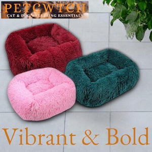 Puede incluir: Tres camas afelpadas para mascotas en tonos rosa, burdeos y verde azulado. Las camas son rectangulares y redondas, con una textura suave. La pancarta superior dice "PETCWITCH CAT & DOG WELLBEING ESSENTIALS". El texto inferior dice "Vibrant & Bold".