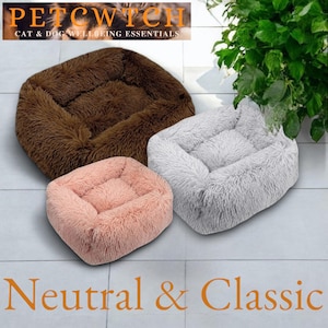 May include: Three plush pet beds in brown, pink, and gray. The beds have a rectangular shape with raised sides and a soft, fluffy texture. The top of the image has the text "PETCWITCH CAT & DOG WELLBEING ESSENTIALS". The bottom of the image has the text "Neutral & Classic".