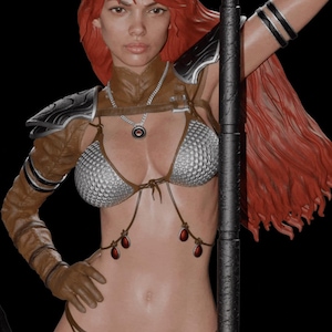 May include: A woman with long red hair is wearing a silver chainmail bikini top and brown leather armor. She is holding a black metal staff with one hand and her other hand is on her hip.