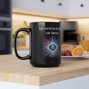 May include: Black ceramic coffee mug with a white design that says "Quantum State of Mind". The design features a blue and purple circuit board with a glowing blue chip in the center.