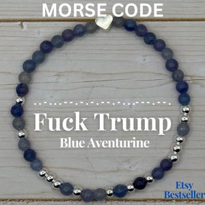 May include: Blue aventurine beaded bracelet with silver accents. The bracelet has the text "Fuck Trump" and "Blue Aventurine" in white. The top of the image reads "Morse Code". A small silver heart charm is also included.