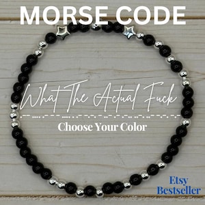 May include: Black beaded bracelet with silver accents and star charms. The bracelet features the text "MORSE CODE" and "What The Actual Fuck". The phrase "Choose Your Color" is also visible.