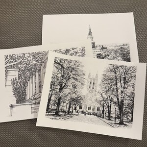 Op de afbeelding: Drie zwart-wit architectuurschetsen. E&eacute;n toont een gebouw met een torenspits, een ander een gebouw met klimplanten en de derde een kerk met een klokkentoren, allemaal op wit papier.
