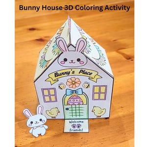May include: A 3D paper bunny house coloring activity. The house is decorated with a flower, bees, and a bunny with the text "Bunny's Place". The door has a checkered pattern and an Easter egg design. The house has a welcome sign that says "Welcome Friends!"