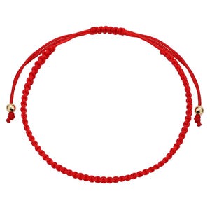 May include: A red macrame bracelet with adjustable sliding knots. The bracelet features a series of small, tightly knotted red threads forming a circular design. Gold-colored beads are at each end of the bracelet.