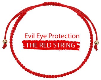 May include: A red string bracelet with gold-colored beads at the ends. The bracelet features the text "Evil Eye Protection" and "THE RED STRING" in white letters on a white background.