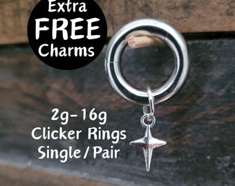 May include: Silver clicker rings in sizes 2g-16g, available as a single ring or a pair. The rings have a star-shaped charm attached. The text "Extra FREE Charms" is visible in the image.