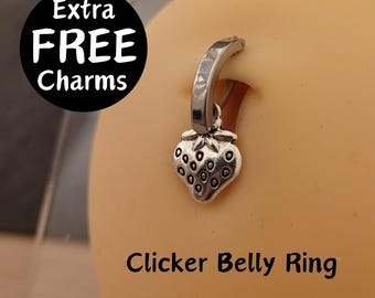 May include: Silver belly ring with a strawberry charm. The ring is a clicker style and has a smooth finish. The charm is detailed and has a realistic look. The text "Extra FREE Charms" is in a black circle in the top left corner of the image. The text "Clicker Belly Ring" is in the bottom center of the image.