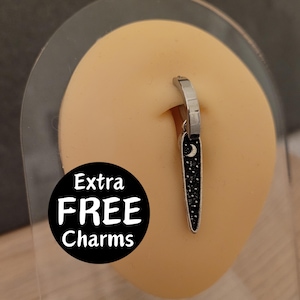 May include: A silver hoop earring with a black and silver dangle charm featuring a crescent moon and stars. The charm is shaped like a long, thin spike. The text "Extra FREE Charms" is visible in the image.