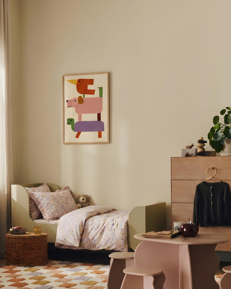Puede incluir: Un dormitorio infantil con una cama verde claro, ropa de cama floral y un estampado enmarcado de formas de animales apiladas. Una peque&ntilde;a mesa y sillas est&aacute;n en primer plano, y una c&oacute;moda con un c&aacute;rdigan colgando est&aacute; en el fondo. La habitaci&oacute;n tiene una paleta de colores neutros.