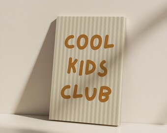 May include: A rectangular canvas with a striped background in beige and light gray. The words "COOL KIDS CLUB" are printed in a bold, orange-brown font. The canvas is leaning against a white surface.