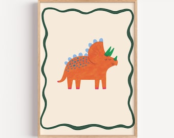 May include: A framed print featuring a cartoon Triceratops dinosaur. The dinosaur is orange with blue spots and green horns, set against a cream background with a green border. The artwork has a playful, whimsical style.