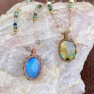 May include: Two necklaces with labradorite stone pendants. The pendants are wrapped in macrame and the necklaces are made with various coloured beads.