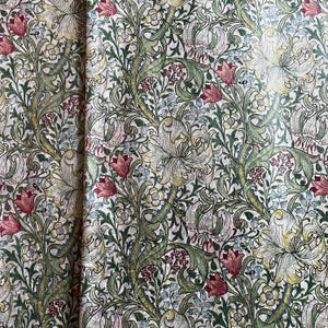 May include: A vintage floral wallpaper with a repeating pattern of lilies, leaves, and flowers in shades of green, white, and pink.